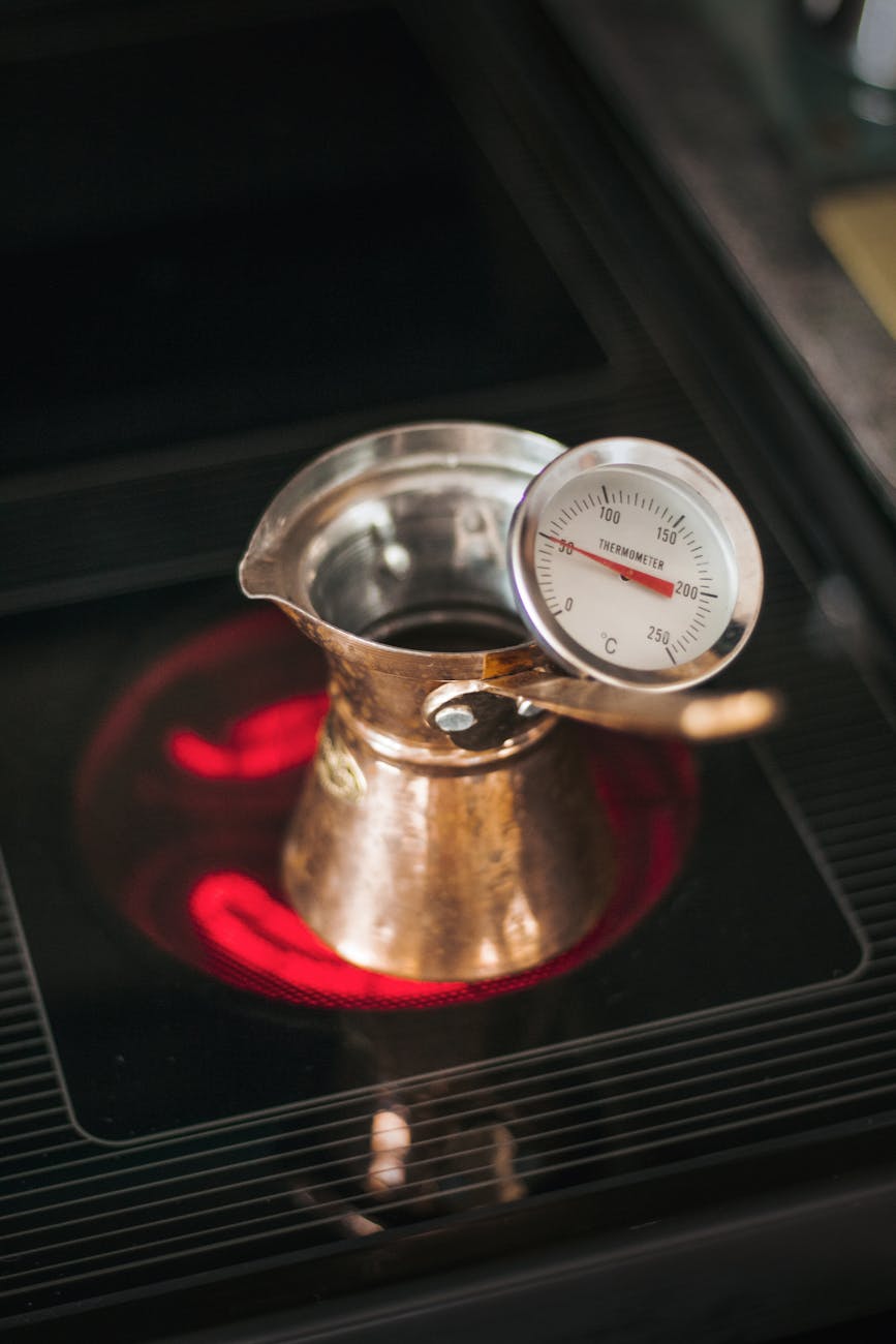 cezve with thermometer on hot stove