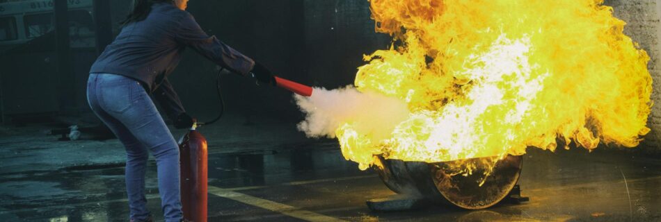 woman using fire extinguisher to eliminate fire